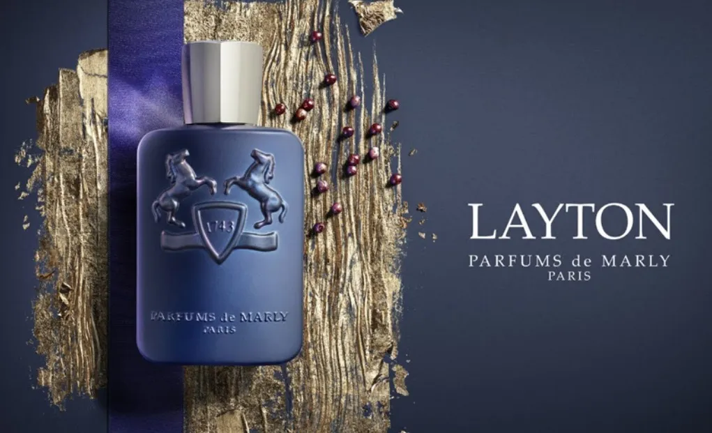 Frasco do perfume Layton Parfums de Marly em tom azul elegante com detalhes em relevo, posicionado em cenário sofisticado com fundo artístico dourado, transmitindo luxo e exclusividade.